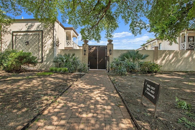 view of front facade with a fenced front yard, a gate, and stucco siding