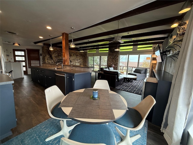 dining room featuring ceiling fan, sink, beamed ceiling, and dark wood-type flooring