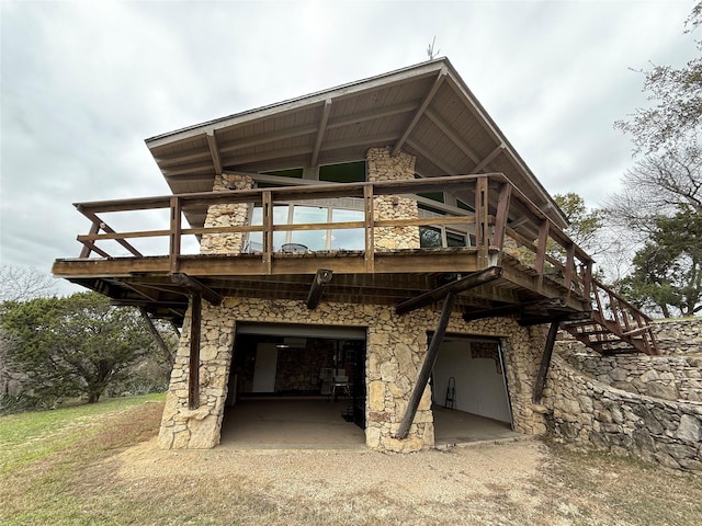 back of house featuring a wooden deck and a garage