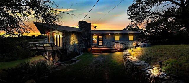 view of front of house featuring a deck and a lawn