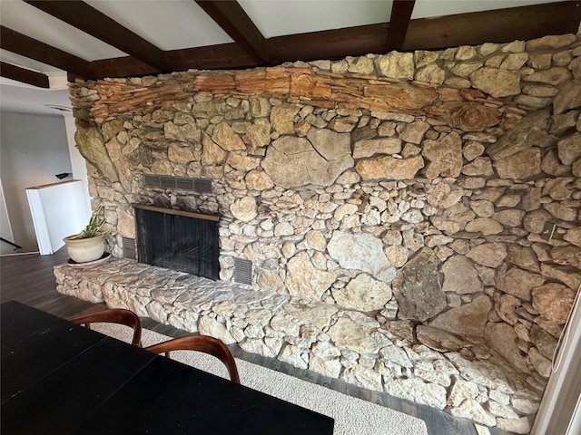 interior details featuring beamed ceiling, hardwood / wood-style flooring, and a fireplace