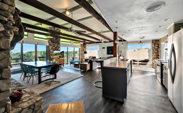 dining room with beamed ceiling, ceiling fan, dark hardwood / wood-style floors, and sink