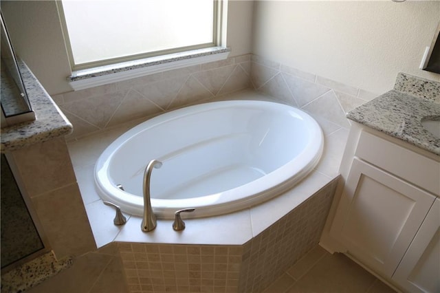 bathroom with a relaxing tiled tub and vanity