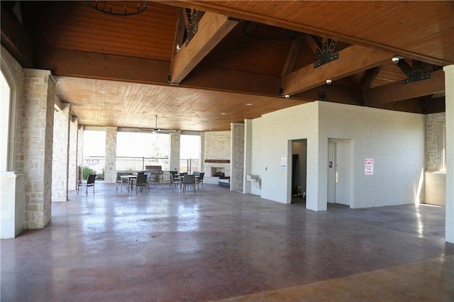 interior space with high vaulted ceiling, a large fireplace, concrete floors, and wood ceiling