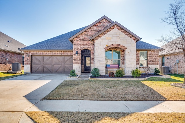 view of front facade featuring central AC, a garage, and a front lawn