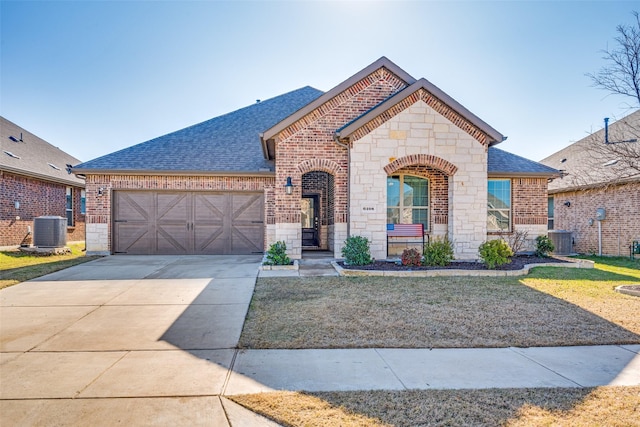 view of front of property featuring a garage, central air condition unit, and a front yard