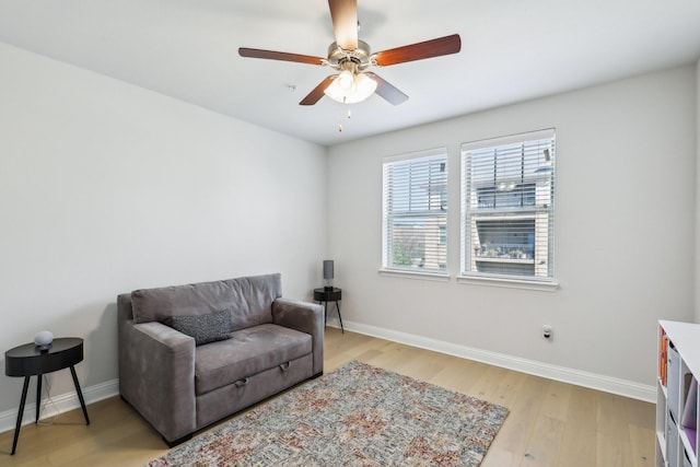 living area with ceiling fan and light hardwood / wood-style flooring