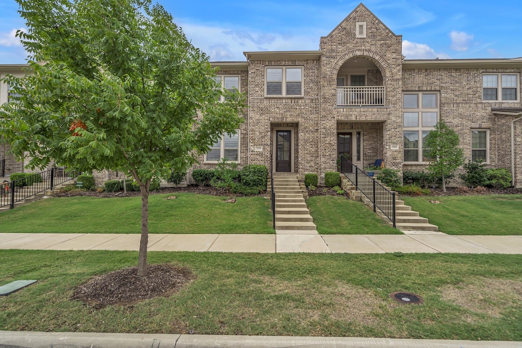 view of front of property with a front yard and a balcony