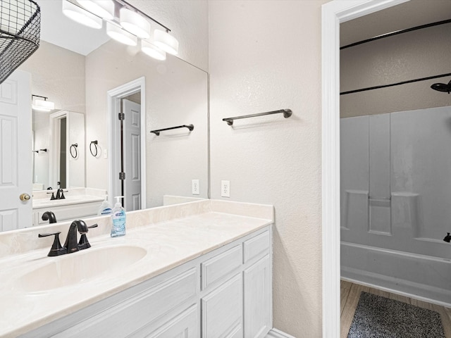 bathroom with shower / tub combination, hardwood / wood-style floors, and vanity