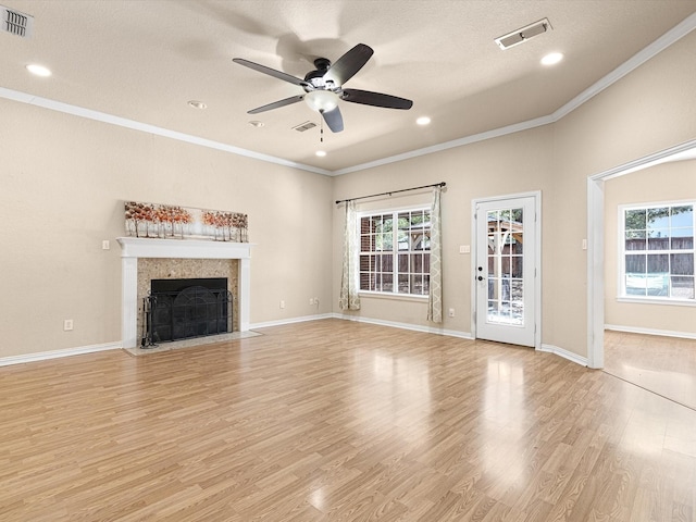 unfurnished living room featuring ceiling fan, a textured ceiling, light hardwood / wood-style flooring, and crown molding