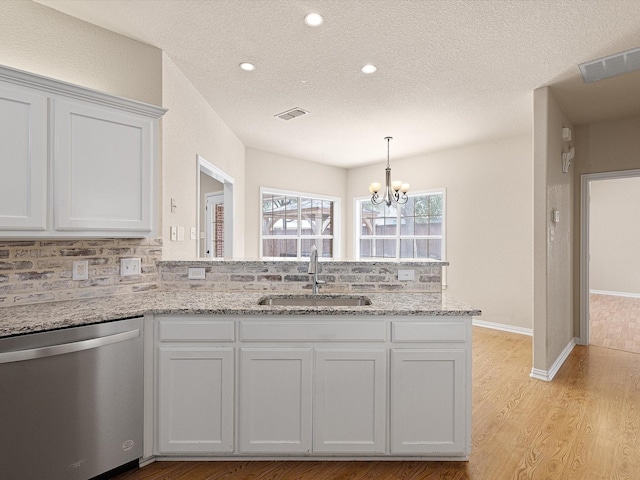 kitchen with dishwasher, white cabinets, sink, light wood-type flooring, and a textured ceiling