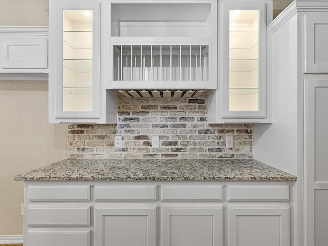 kitchen with light stone countertops and white cabinetry