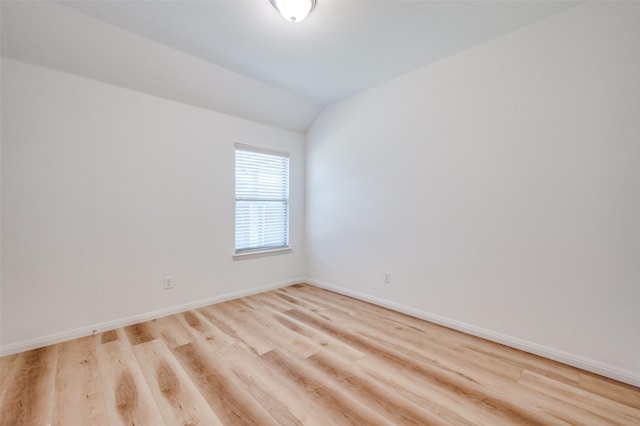 empty room featuring light hardwood / wood-style flooring and vaulted ceiling