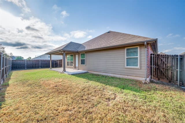 rear view of house featuring a yard and a patio