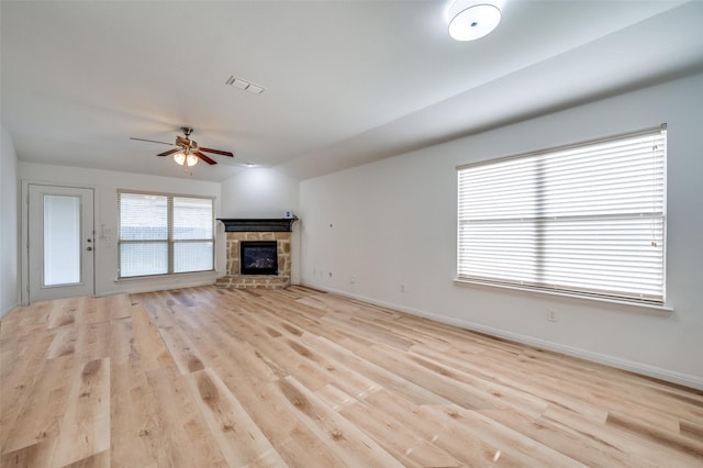 unfurnished living room featuring a fireplace, light hardwood / wood-style floors, and ceiling fan