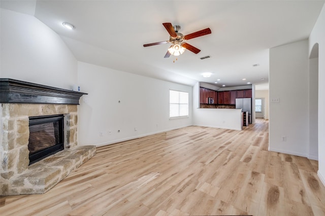 unfurnished living room with a fireplace, light hardwood / wood-style floors, and ceiling fan