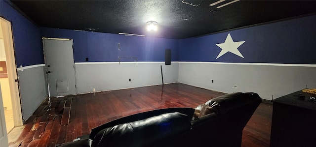 home theater room featuring hardwood / wood-style flooring and a textured ceiling