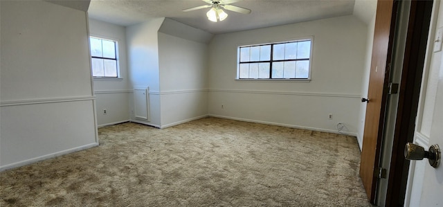 carpeted empty room featuring ceiling fan and lofted ceiling