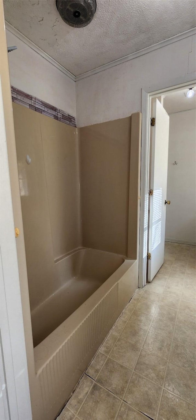 bathroom featuring washtub / shower combination and a textured ceiling