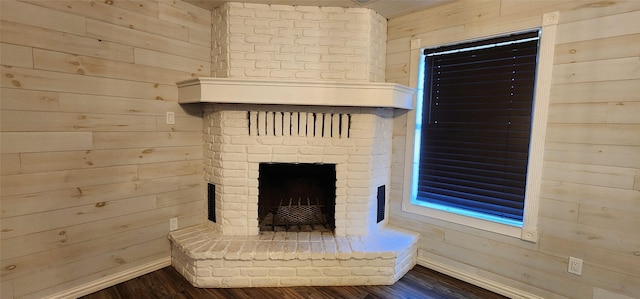 interior details with wood-type flooring, a fireplace, and wood walls