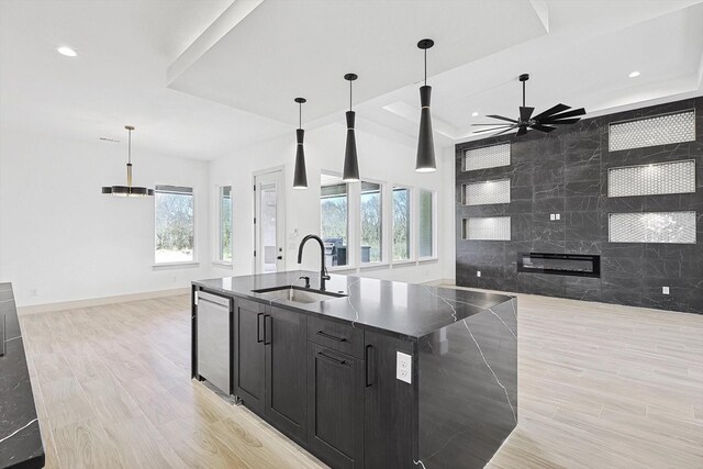 kitchen with pendant lighting, a kitchen island with sink, sink, stainless steel dishwasher, and ceiling fan