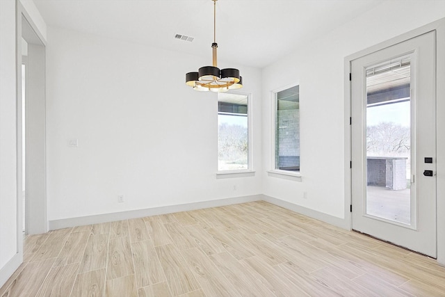 interior space with light hardwood / wood-style floors and a notable chandelier