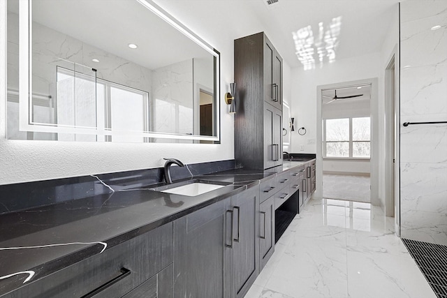 bathroom with vanity and ceiling fan with notable chandelier