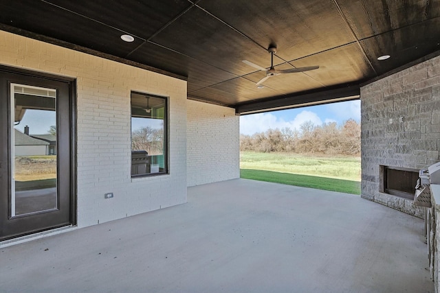 view of patio / terrace with ceiling fan and an outdoor stone fireplace