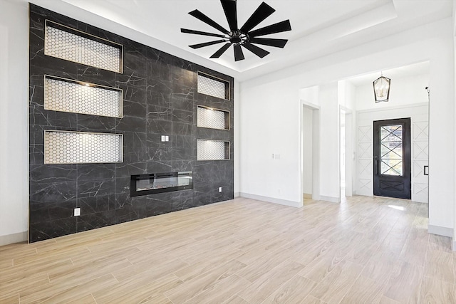 foyer entrance featuring ceiling fan and a raised ceiling