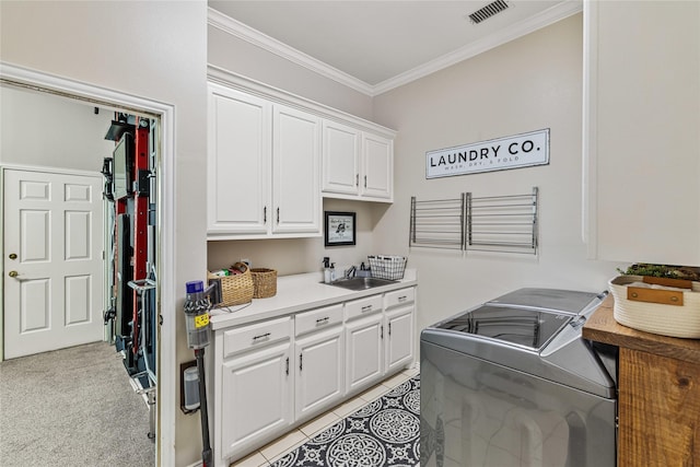 kitchen featuring sink, crown molding, light carpet, washing machine and dryer, and white cabinets