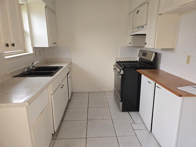 kitchen with white cabinets, stainless steel gas stove, premium range hood, and sink