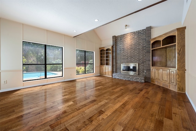 unfurnished living room featuring dark hardwood / wood-style flooring, a fireplace, and vaulted ceiling