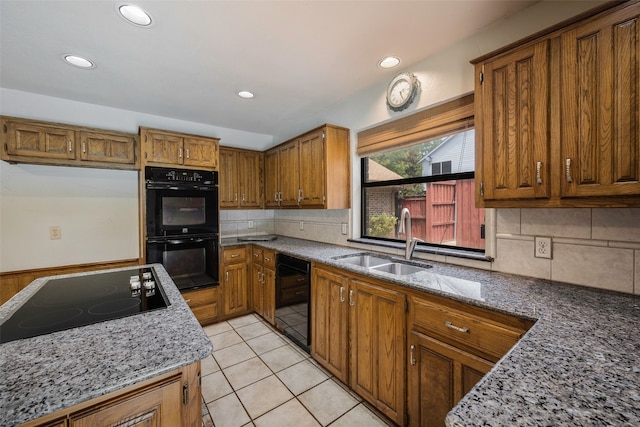 kitchen featuring light tile patterned floors, sink, backsplash, and black appliances