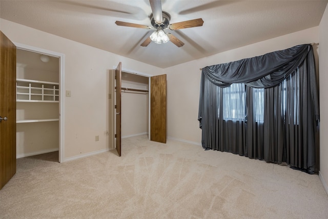 unfurnished bedroom featuring ceiling fan, light carpet, and a closet