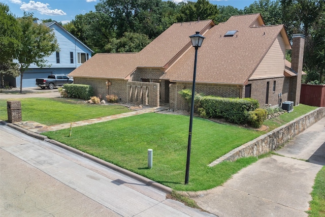 view of front facade with cooling unit and a front lawn