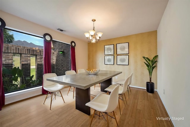 dining area with a chandelier, light wood-type flooring, and plenty of natural light