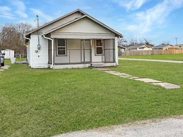 bungalow with covered porch and a front lawn