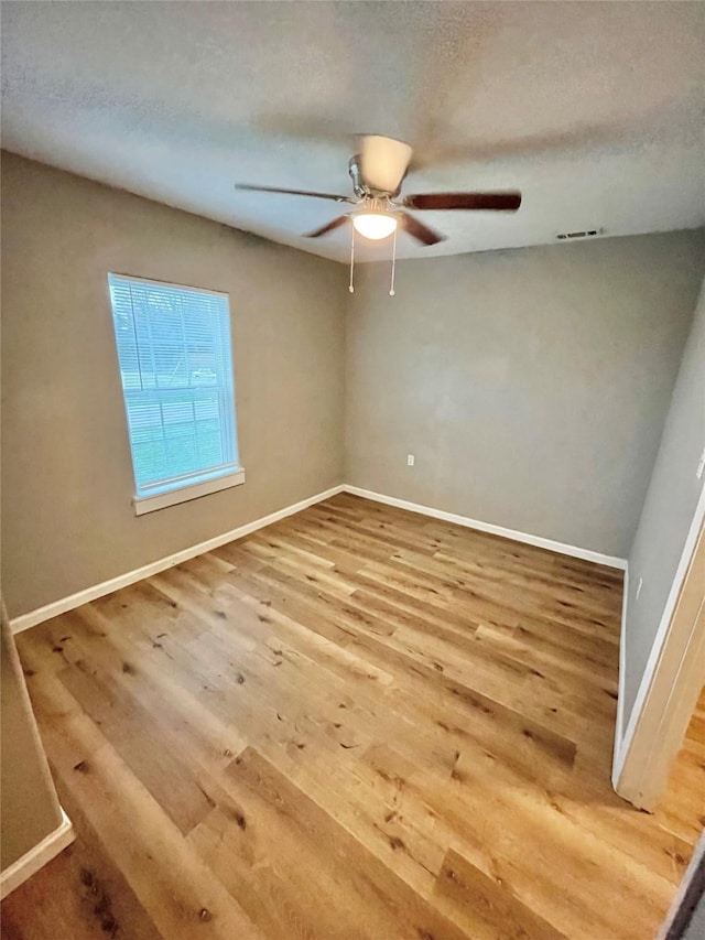 spare room featuring ceiling fan, hardwood / wood-style floors, and a textured ceiling