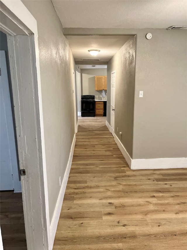 hallway with light hardwood / wood-style flooring