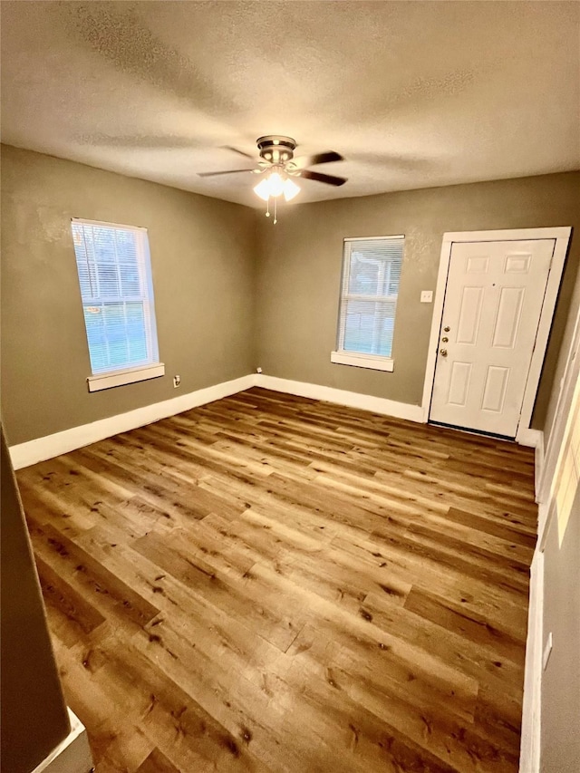 foyer entrance featuring hardwood / wood-style flooring, ceiling fan, and a textured ceiling