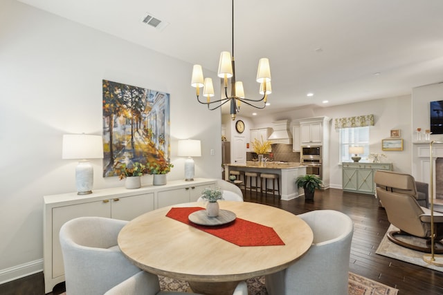 dining space featuring dark wood-type flooring and a chandelier