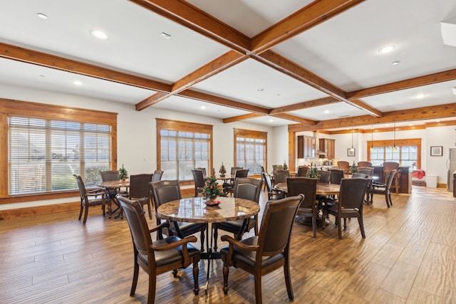 dining space with beamed ceiling, coffered ceiling, and light hardwood / wood-style floors