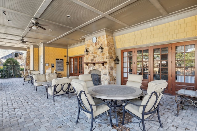 view of patio / terrace with french doors, ceiling fan, and an outdoor stone fireplace