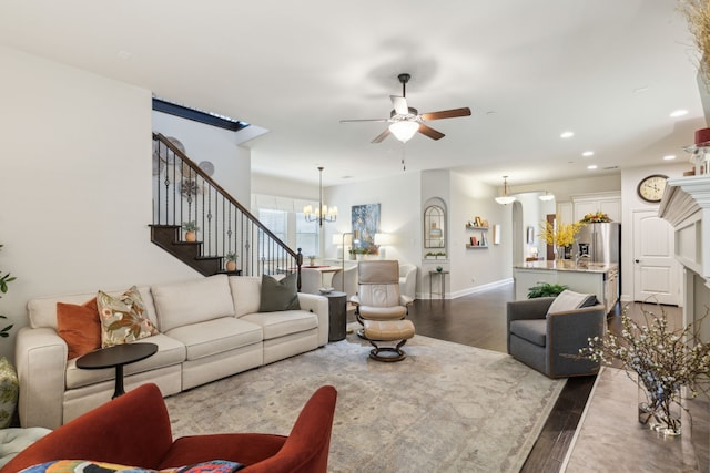 living room with dark hardwood / wood-style floors and ceiling fan with notable chandelier