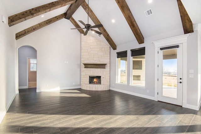 unfurnished living room with a wealth of natural light, ceiling fan, a stone fireplace, and high vaulted ceiling