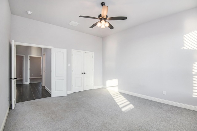 unfurnished bedroom featuring ceiling fan and dark carpet