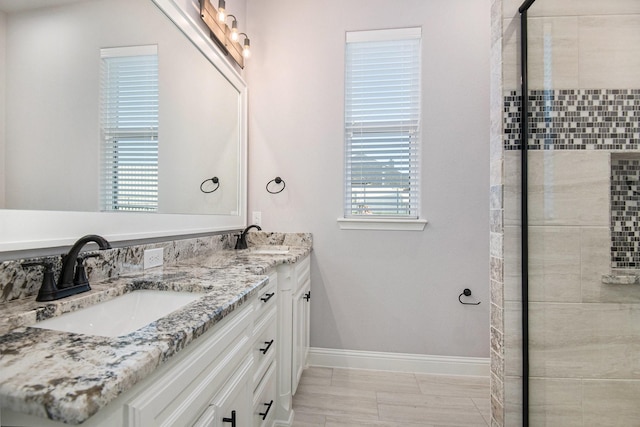 bathroom with tile patterned flooring, vanity, a healthy amount of sunlight, and an enclosed shower