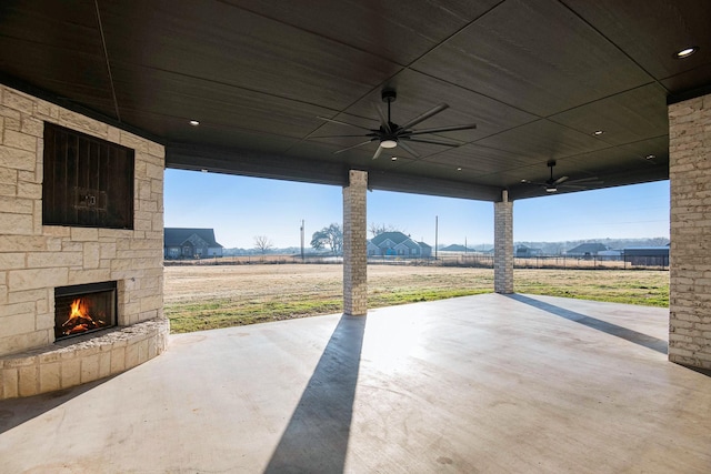 view of patio / terrace featuring an outdoor stone fireplace and ceiling fan