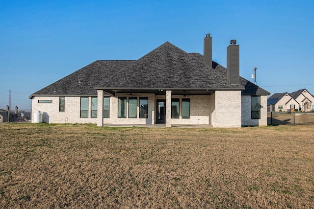 back of property with a lawn, ceiling fan, and a patio area