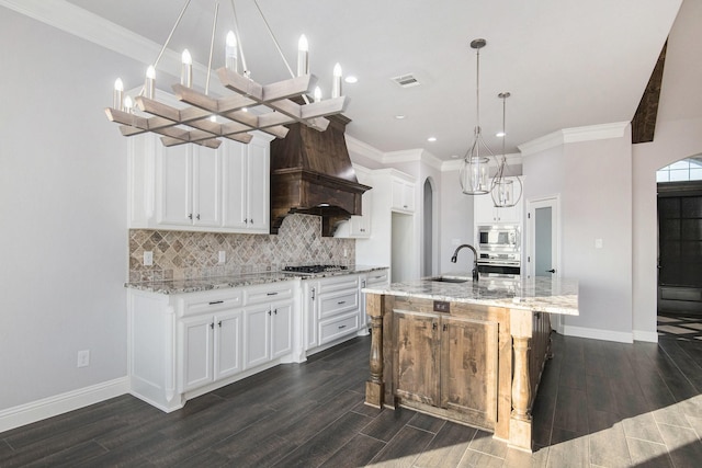 kitchen with stainless steel appliances, backsplash, white cabinetry, and a spacious island